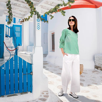 A model wearing white pants and a green blouse with white stripes